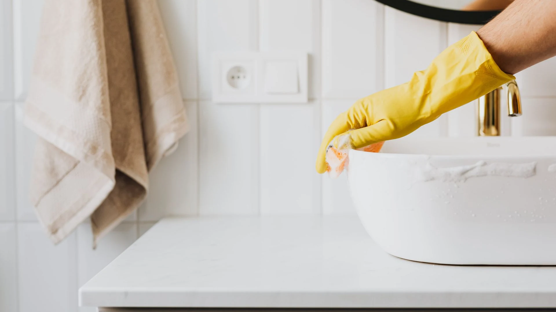 Professional cleaner wiping a bathroom sink